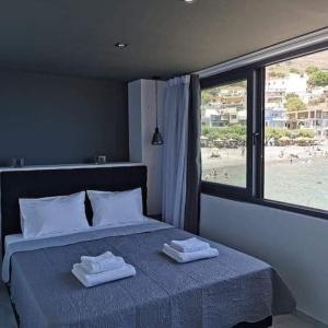 a bedroom with a bed with two towels on it at Sunrise Luxury Seaside Apartment in Paránimfoi