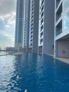 a swimming pool in front of some tall buildings at Sunset Beach View Holiday Homes in Ajman 