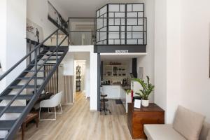a loft apartment with a staircase and a living room at Moderno e Confortevole Loft tra Navigli e Bocconi in Milan