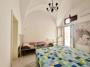 a bedroom with two beds and a chandelier at GALLIPOLI CENTRO STORICO in Gallipoli