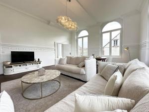 sala de estar con sofá y mesa en L'Orangerie du Château - Outdoor swimming pool, en Blandainville