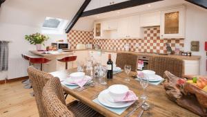a kitchen with a wooden table with plates and wine glasses at The Haven in Norham
