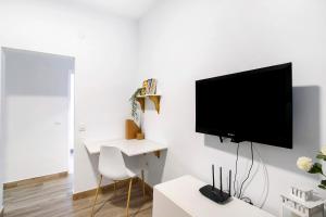 ein Wohnzimmer mit einem Flachbild-TV an einer weißen Wand in der Unterkunft The Greey's House A in Telde
