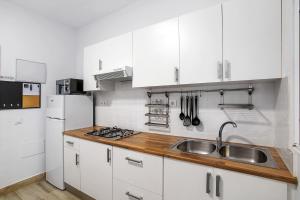 a kitchen with white cabinets and a sink at The Greey's House A in Telde