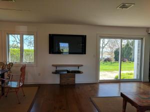 een woonkamer met een flatscreen-tv aan de muur bij Chatham Family retreat:Tennis,water views&access! in Chatham