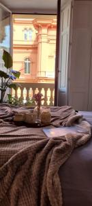 Una cama con una manta y un jarrón de flores. en RossoPetruzzelli, en Bari