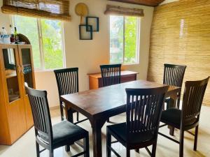 comedor con mesa de madera y sillas en JP Hostels & Apartment, en Kandy