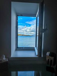 a window in a bathroom with a view of the water at Studio House in St Margaret's Hope