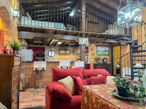 a living room with a red couch and a table at VILLA AMANECER in Candeleda