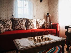 a living room with a red couch with a chess board at Na wsi Zalesie 53 in Wyszki