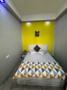 ein Schlafzimmer mit einem großen Bett mit gelber Wand in der Unterkunft Comfy Apartment with a Spacious Balcony Self Check In in Yerevan