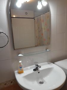 La salle de bains est pourvue d'un lavabo blanc et d'un miroir. dans l'établissement Apartamento Nevados 19101, à Anciles