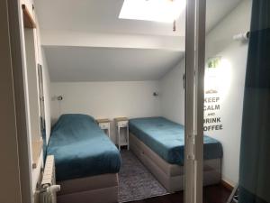 um pequeno quarto com 2 camas e um espelho em Casa Martinho em São Martinho do Porto
