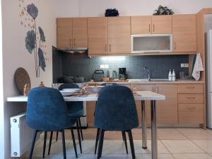 a kitchen with a table and two blue chairs at Sapphire apartment in Agios Nikolaos