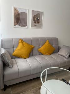 sala de estar con sofá y almohadas amarillas en Exyca Metropolitano, en Madrid
