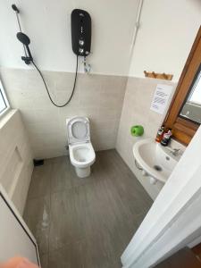 małą łazienkę z toaletą i umywalką w obiekcie The Grand Bali Hotel w Malakce