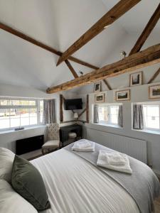 a bedroom with a white bed in a room at Pear & Olive Cottage in Hildersham