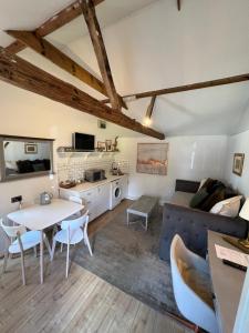 a living room with a couch and a table at Pear & Olive Cottage in Hildersham