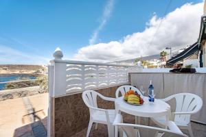een kleine witte tafel en stoelen op een balkon bij Casa Pedro Julio Atlantic Sunset in Adeje