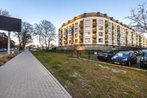 a building with cars parked in a parking lot at Stylish Apartment Grunwaldzka by Rent like home in Świnoujście