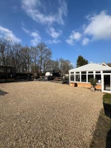 a large white building with a gravel driveway at Pear & Olive Cottage in Hildersham