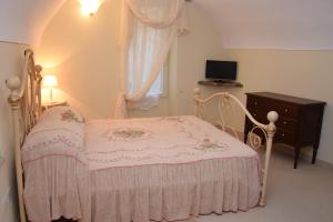 - une chambre avec un lit rose, une commode et une fenêtre dans l'établissement Corte Doria Dolceacqua Agriturismo, à Dolceacqua