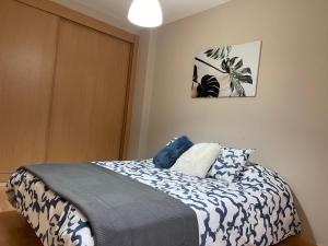 - une chambre dotée d'un lit avec des draps bleus et blancs dans l'établissement Piso Ría de Cedeira, à Cedeira