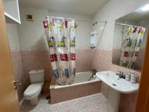 La salle de bains est pourvue de toilettes, d'une baignoire et d'un lavabo. dans l'établissement Piso Ría de Cedeira, à Cedeira