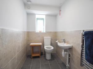 a bathroom with a toilet and a sink at Swydd Long Barn Swyddffynnon in Ystrad-Meurig