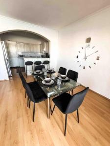 a dining room with a table and chairs and a clock at Bay view Appartment in Paceville