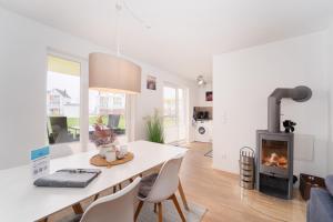 a living room with a fireplace and a table and chairs at Heimathafen Schlei in Olpenitz