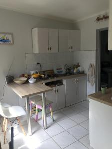 a kitchen with white cabinets and a table at Fiołek - domek nad Szelągiem Wielkim in Ostróda +12 photos
