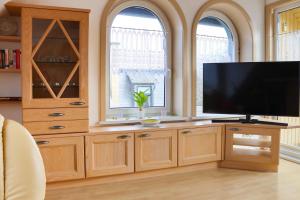 a living room with a large entertainment center with a flat screen tv at Ferienwohnung -Villa Am Stadtpark- Blankenburg mit Balkon und Sauna in Blankenburg