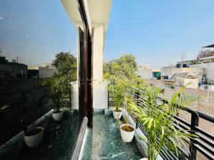 Un balcón con un montón de macetas. en BedChambers Serviced Apartments South Extension, en Nueva Delhi