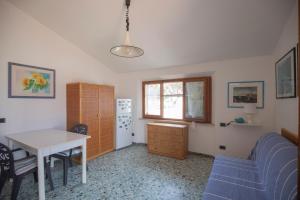 salon ze stołem i niebieską kanapą w obiekcie La Torretta - HelloElba w mieście Marina di Campo