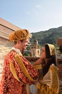 un homme et une femme en costumes debout côte à côte dans l'établissement Corte Doria Dolceacqua Agriturismo, à Dolceacqua
