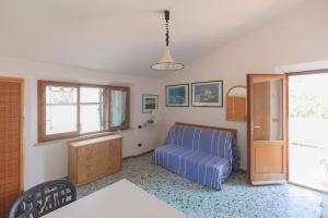 sypialnia z niebieskim łóżkiem i oknem w obiekcie La Torretta - HelloElba w mieście Marina di Campo