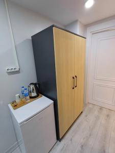 uma cozinha com um armário preto e de madeira ao lado de um frigorífico em White Palace Hotel em Istambul