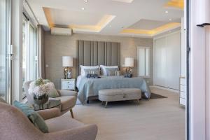 a bedroom with a bed and a couch and chairs at Phenthouse Monaco - Jacuzzi - City Center - Sea View in Albufeira