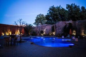 a resort with two pools in front of a mountain at Hotel La Perle du Sud in Ouarzazate