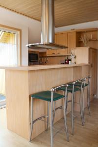 a kitchen with two chairs and a counter with a stove at Ferienwohnung -Villa Am Stadtpark- Blankenburg mit Balkon und Sauna in Blankenburg