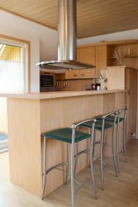 a kitchen with two chairs and a counter with a stove at Ferienwohnung -Villa Am Stadtpark- Blankenburg mit Balkon und Sauna in Blankenburg