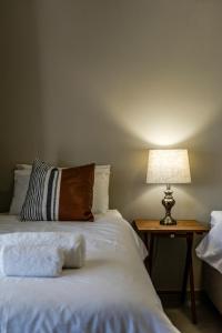 1 dormitorio con 1 cama con lámpara en una mesa en Stofpad Lodge and Camping, 