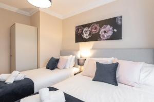 two beds in a room with white and blue pillows at Central 1BED APT RELIABLE FAST WIFI & TV in Dublin