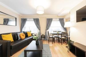 a living room with a black couch and a dining room at Central 1BED APT RELIABLE FAST WIFI & TV in Dublin