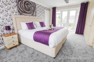 a bedroom with a large bed with purple sheets at 5 bed house, cntrl bmouth, free parking, garden - Talbot House in Bournemouth