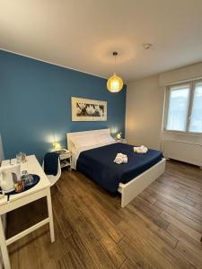 een slaapkamer met een bed en een blauwe muur bij Airuno Rooms in Airuno