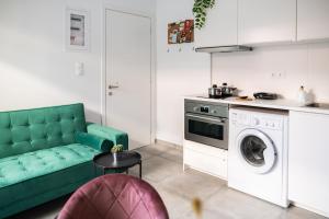 a kitchen with a green couch and a washing machine at Cozy & Chic - 1 bd Apartment in Ampavris