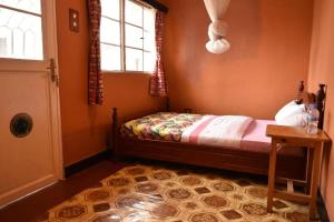 a small bedroom with a bed and a window at Room in BB - Amahoro Guest House - Double Room with Private Shower Room in Ruhengeri