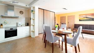 kuchnia i jadalnia ze stołem i krzesłami w obiekcie Wonder Home - Apartament Górska Panorama z widokiem na uzdrowisko i Góry Izerskie w Świeradowie Zdroju